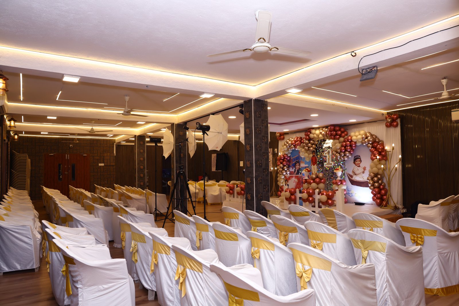 The main hall with rows of white and gold chairs leading to the stage