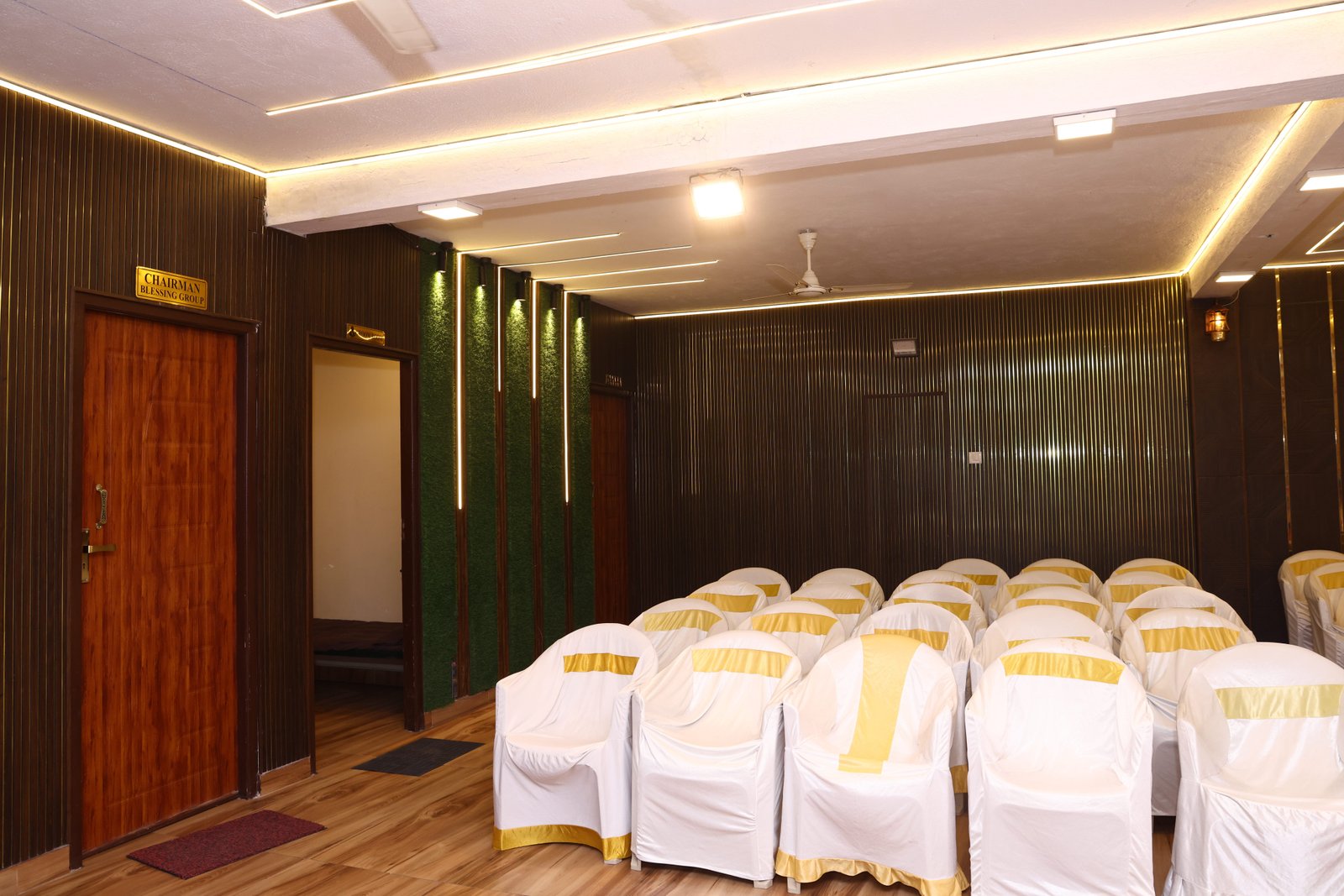 The dining hall with its living green wall and gold-sashed seating